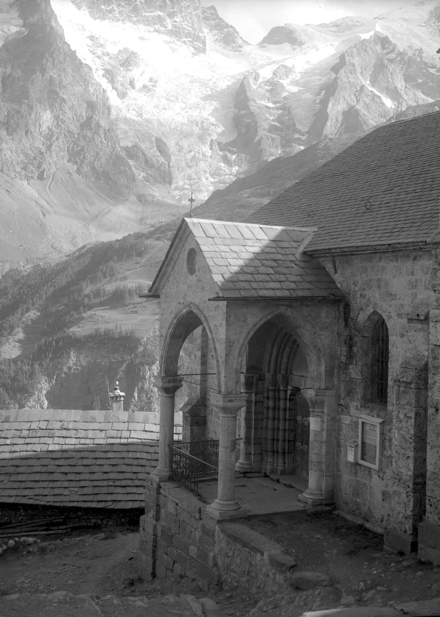 Photographie de l'église des Terrasses avec la Meije en arrière-plan, prise par Henri Ferrand entre 1890 et 1926. Cette 