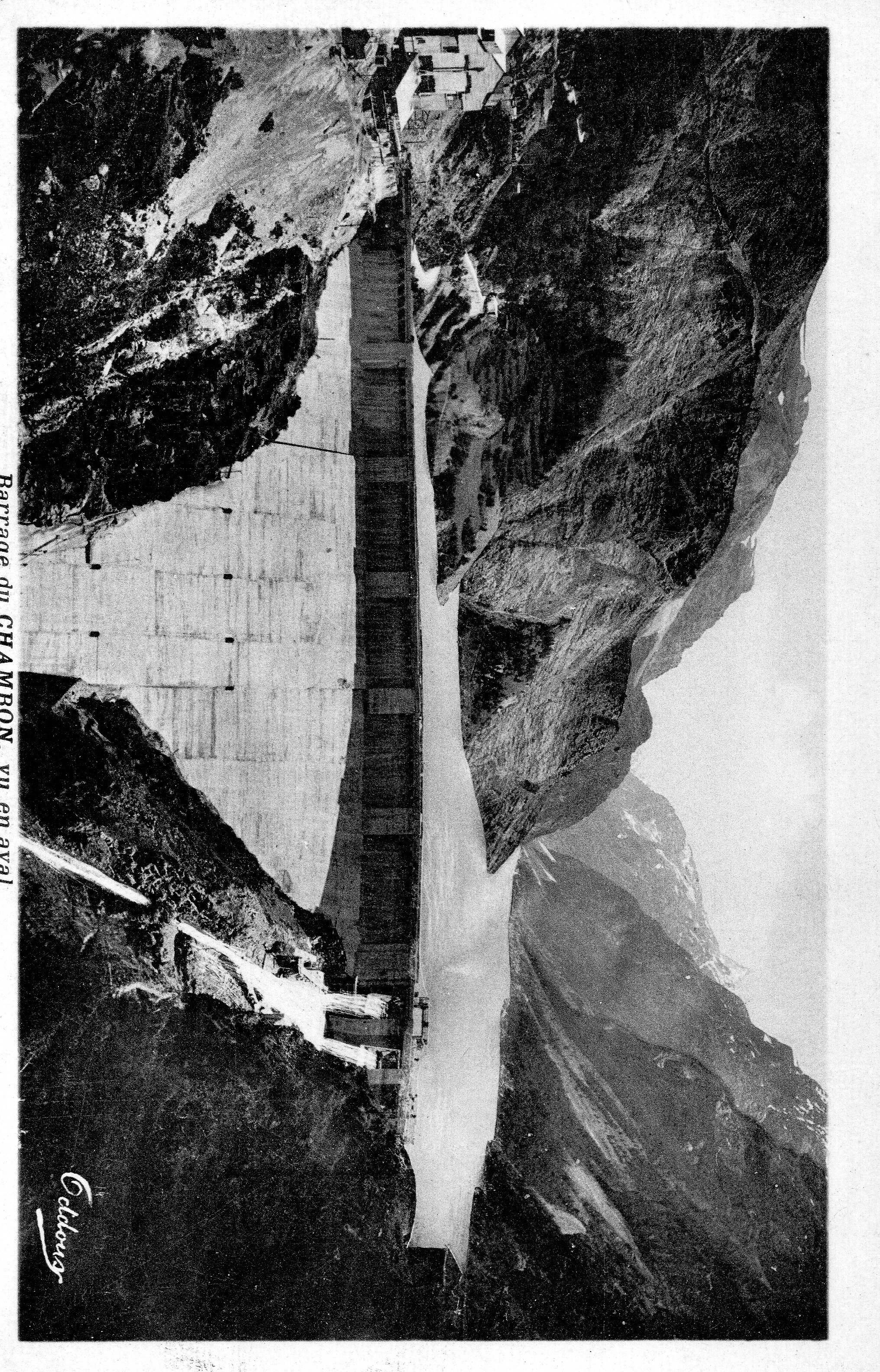 Une vue matinale du barrage en aval, avec l'ombre suivant la courbe de sa structure, créant une atmosphère paisible.