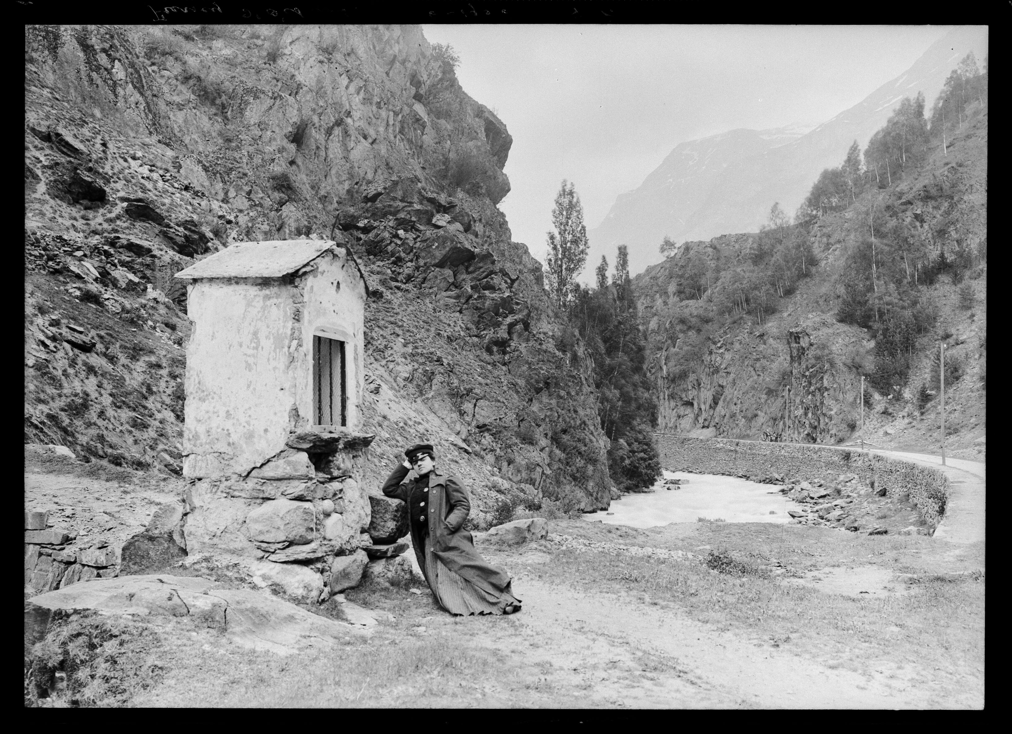 Un homme pose devant un oratoire à la base d'un pont sur la Romanche, près de Mizoen, vers Le Freney, capturé par Émile 